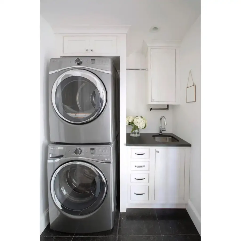 3. Stacked Metallic Washer and Dryer With Dark Countertop