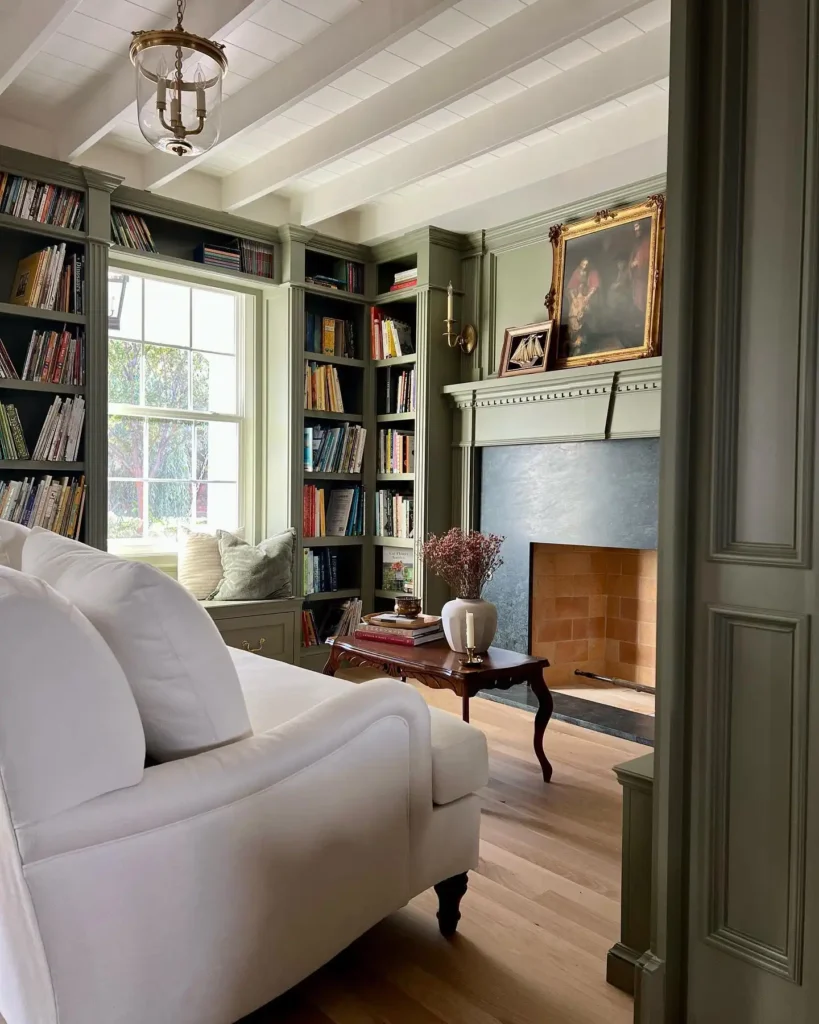 4. Sage Green Library with a Window Seat and Fireplace