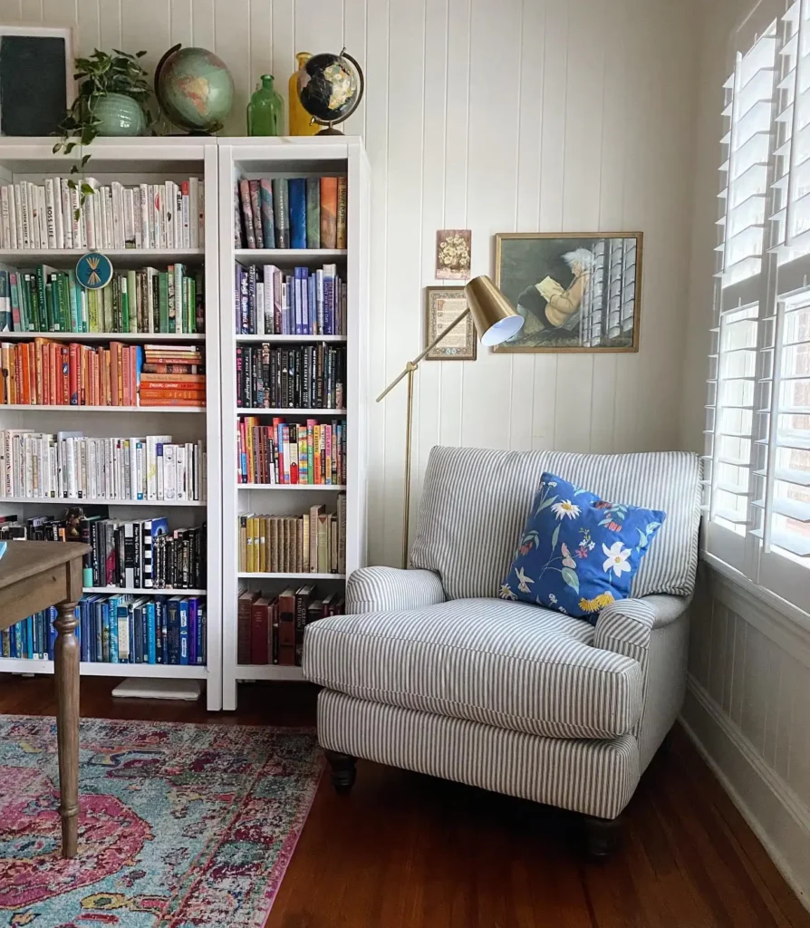 14 Cozy Living Room Reading Corners Built Around One Armchair 5 4. Striped Armchair Beside Rainbow Bookshelves